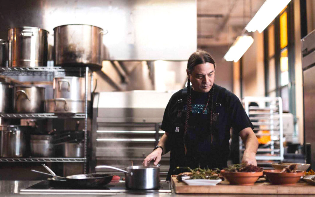 Sean Sherman, award-winning chef and advocate for Indigenous foodways, cooking in a kitchen