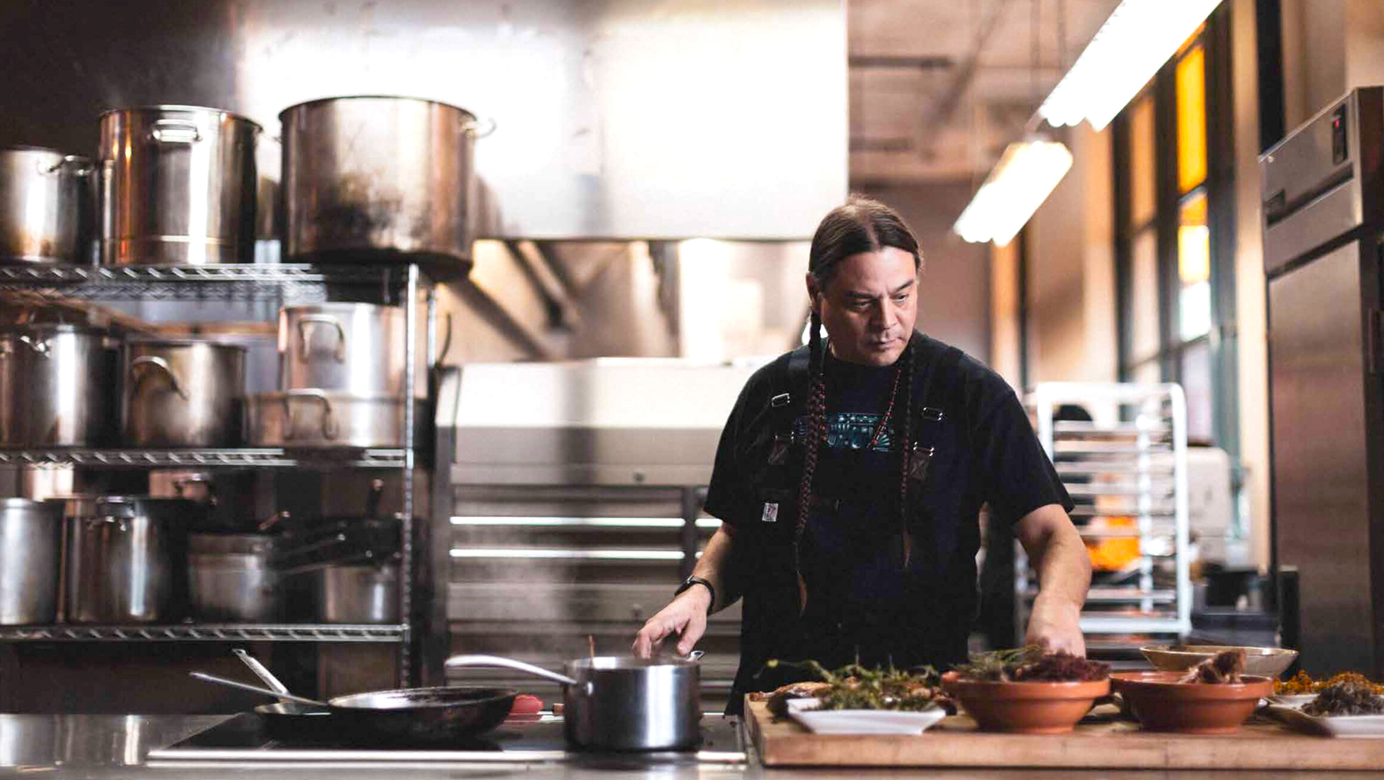 Chef Sean Sherman cooking in restaurant kitchen