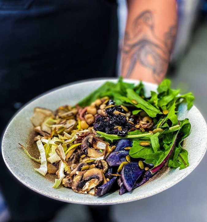 Arm holding plate with colorful Indigenous food