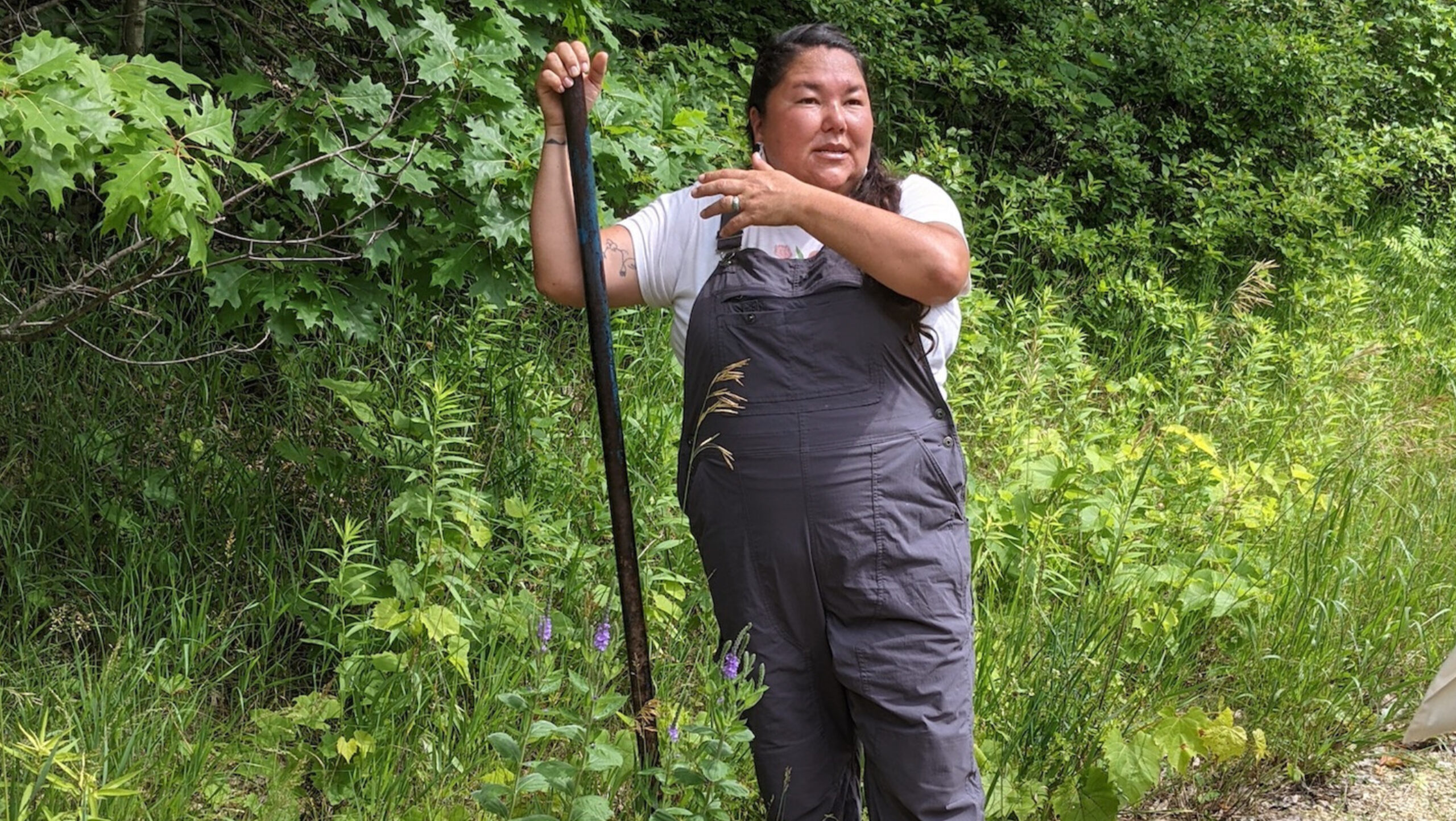 Linda Black Elk holds a shovel on a plant walk
